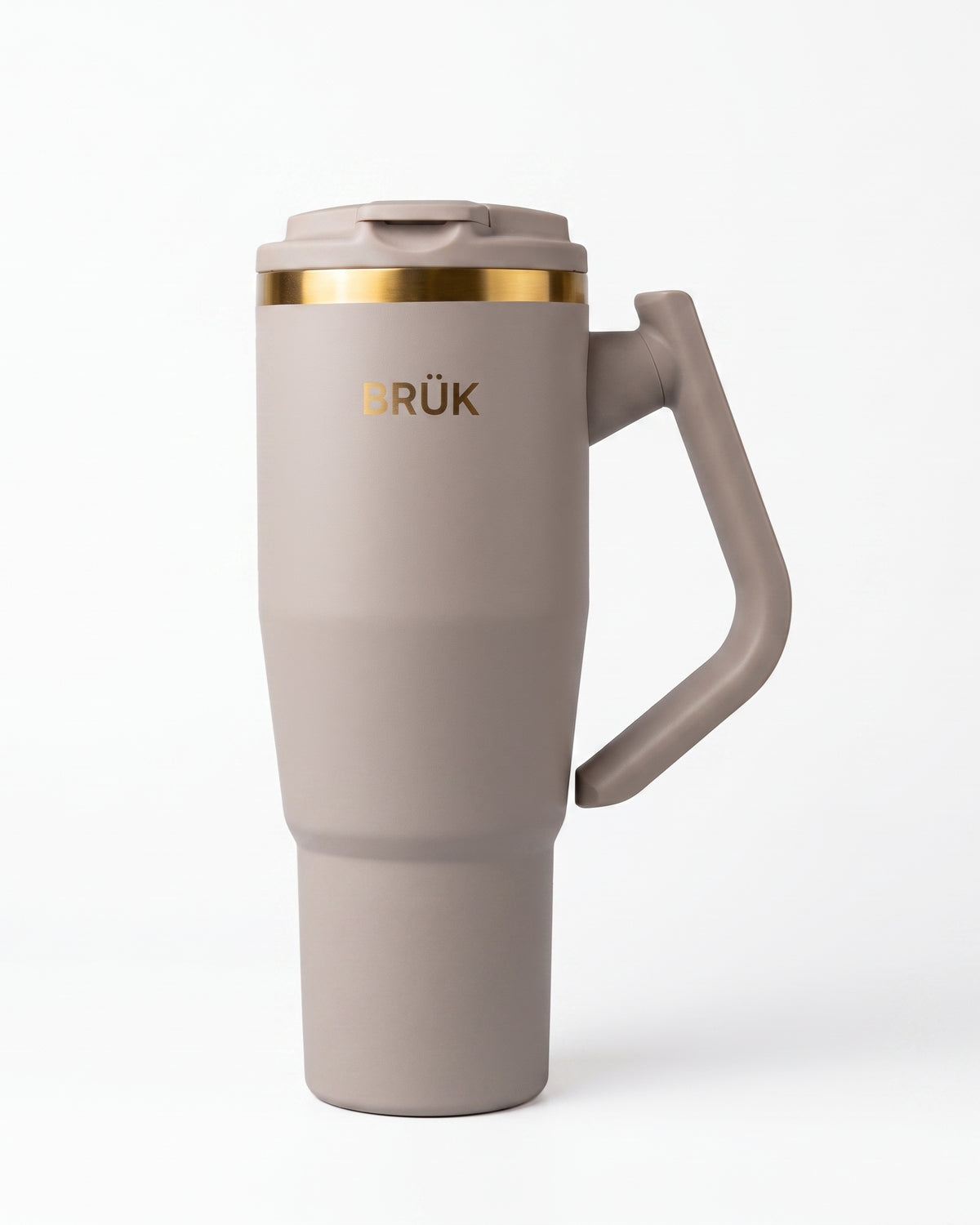 A matte taupe travel mug with a matching handle and lid, featuring a gold metallic band near the lid and the gold 'BRÜK' logo on the front, set against a clean white background.